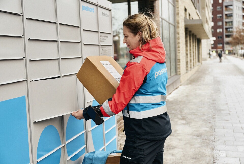 Dame fra PostNord som levere pakker i pakkeboks.