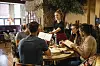 A multi-ethnic group of friends looking at menus together in a restaurant, which have been given to them by a waitress.
