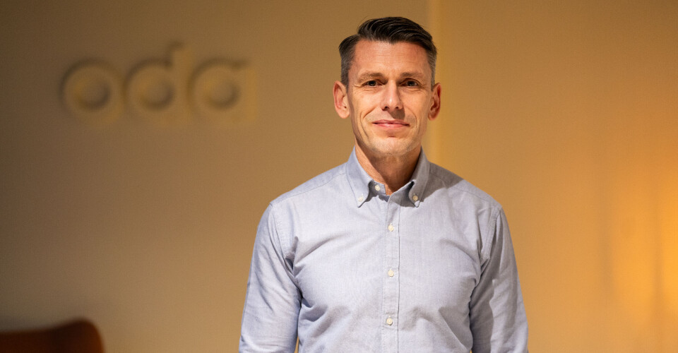 Andre Knüppel, ny CEO i Oda Group. Portrett Andre Knüppel, Oda-logo i bakgrunnen