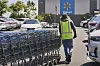 Arbeider rydder handlevogner på parkeringsplass utenfor en Wallmart.