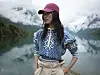 Dame i strikkegenser fra Dale og rød caps. Norsk natur i bakgrunnen