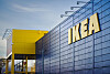 IKEA-varehus med blågrå fasade og gult inngangsparti under en klar himmel.