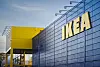 IKEA-varehus med blågrå fasade og gult inngangsparti under en klar himmel.