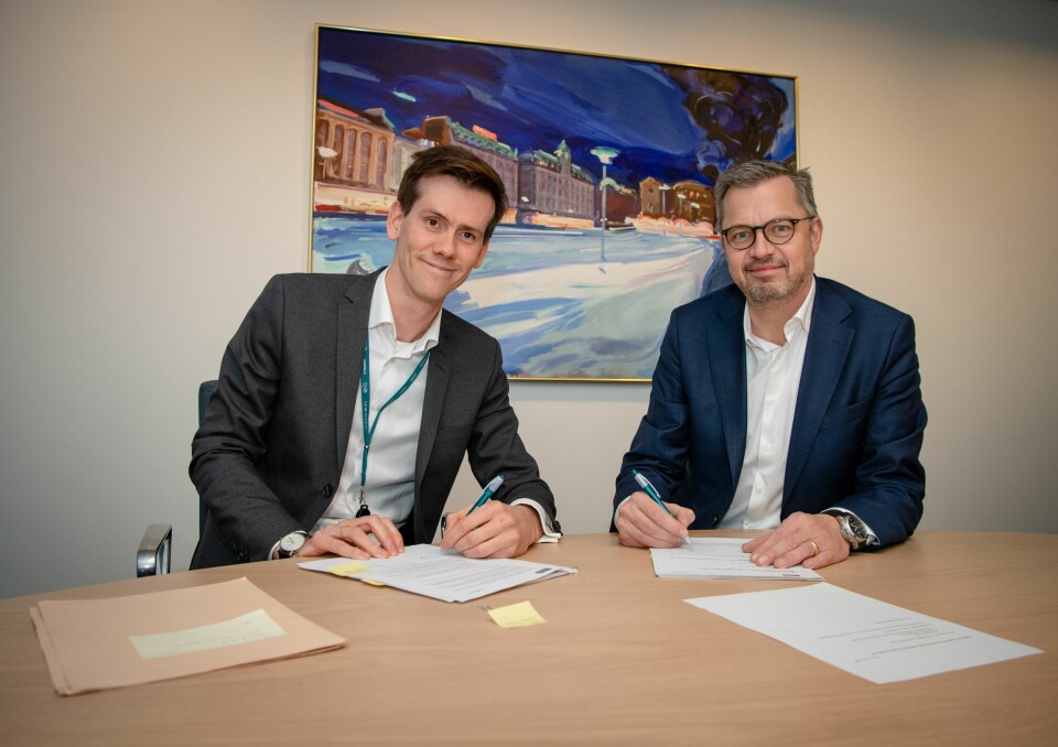 Benjamin Golding fra DNB (t.v.) og Thomas Jul fra Nets signerer avtalen mellom partnerne.