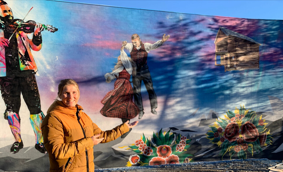 Senterleder Heidi Arnesen foran den graffitidekorerte fasaden.
