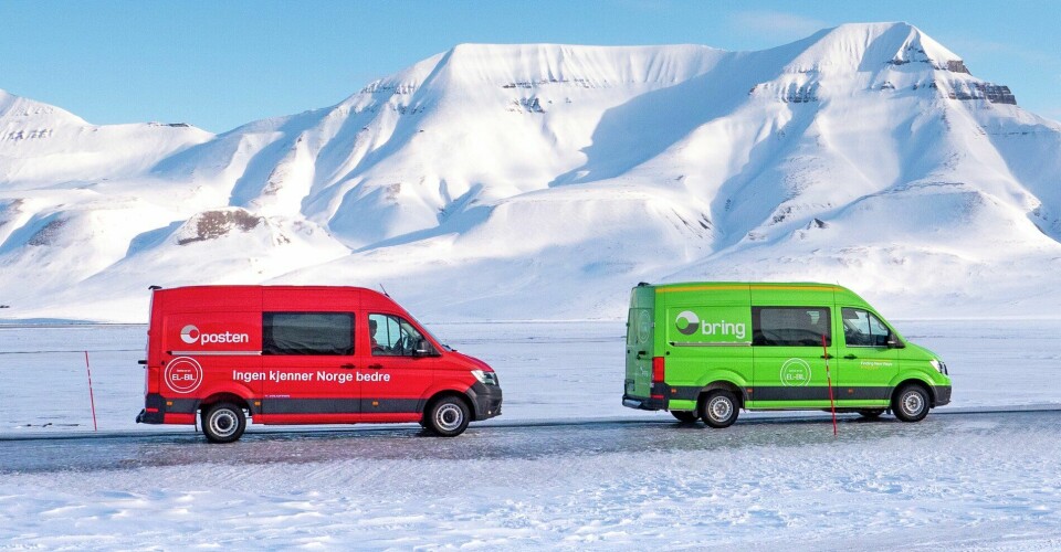 En rød Posentbil og en grønn Bringbil ute på en vei i snøhvitt vinterlandskap. Hvite fjelltopper i bakgrunnen.