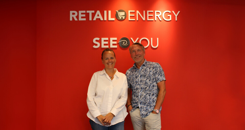 TAnn-Kristin Fiskebeck og Tom-Erik Andersen, stående foran en rød vegg med påskrift Retail Energy og  SeeYou.
