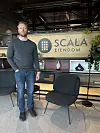 Knut Rolvsjord i et interiør med Scala eiendom på et skilt i bakgrunnen.
