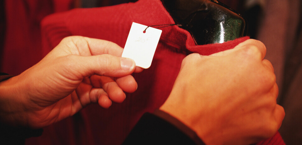 hender som holder ei rød jakke med prislapp